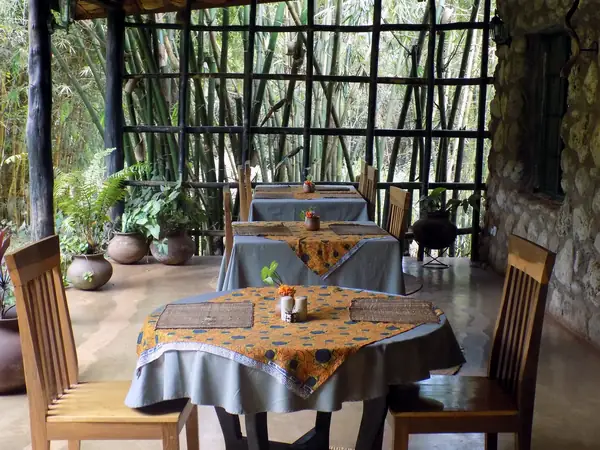 Tables laid in the open-sided dining room under a bamboo roof