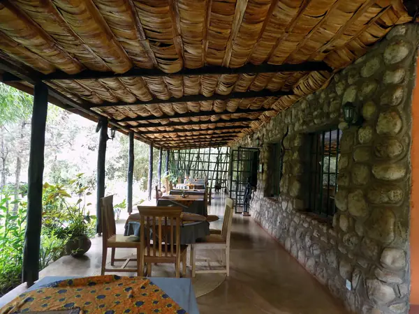 Long covered dining terrace with stone walls