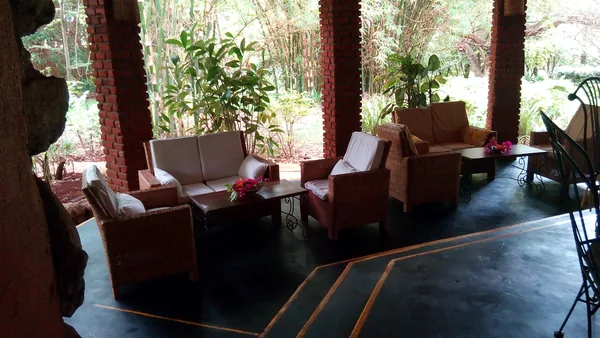 Open-sided lounge with armchairs looking onto the garden