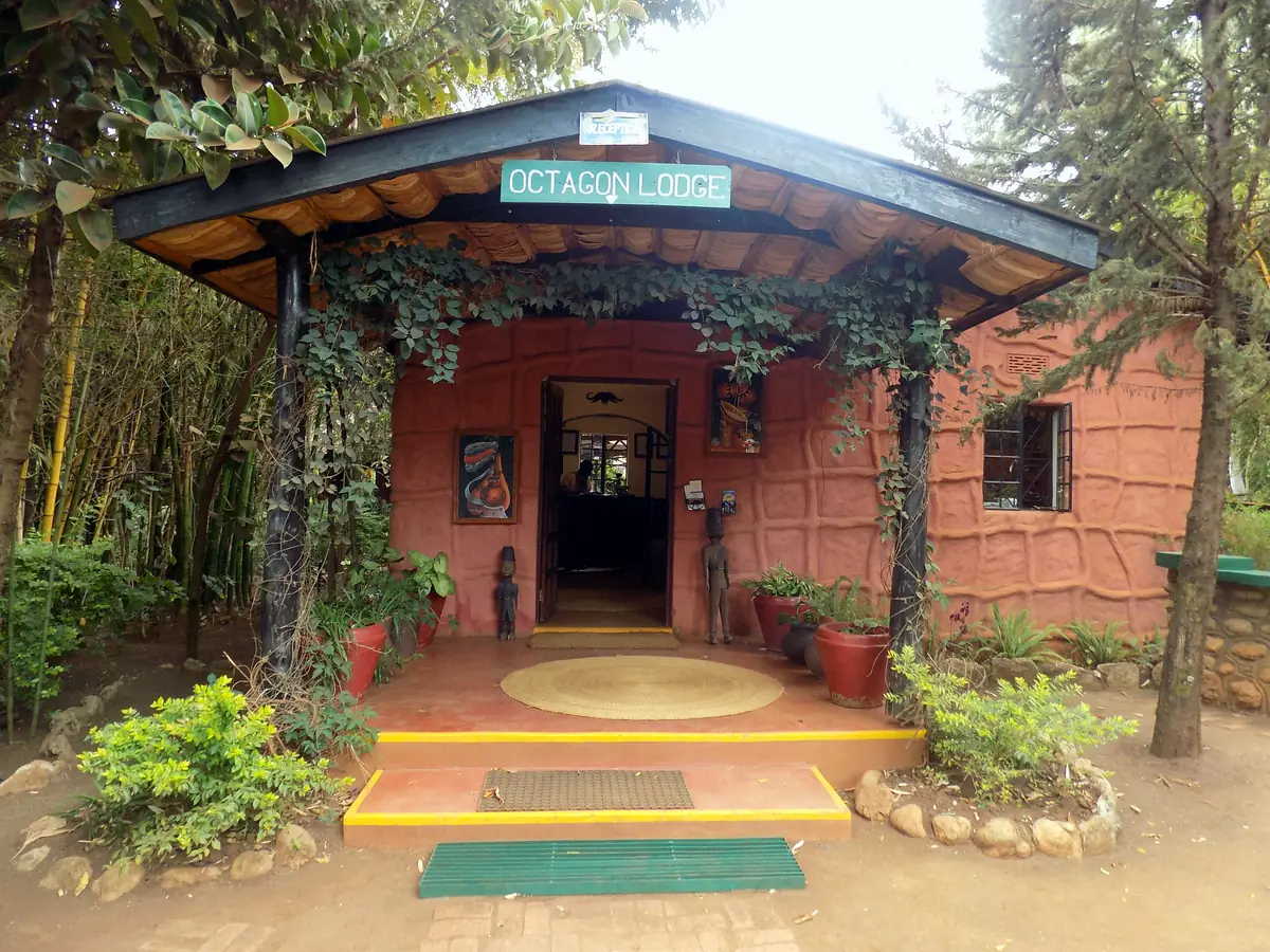 Red-brick reception building with the Octagon Lodge sign, framed by greenery
