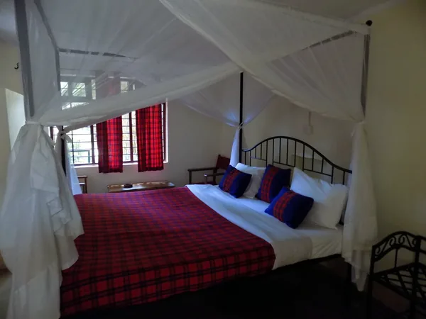 Family room with a red Maasai blanket and mosquito net