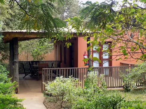 Stone family cottage with a wooden veranda in the garden